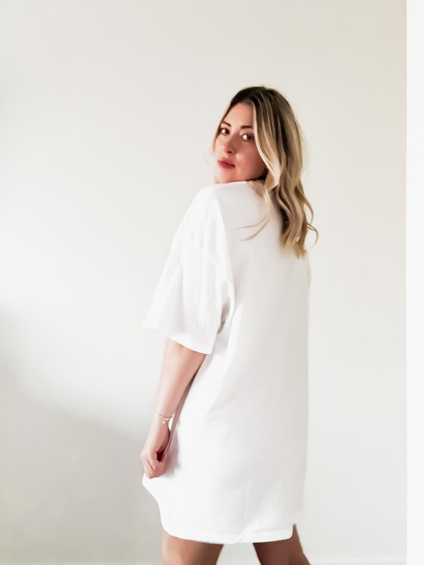 Woman wearing a white dress against a plain background