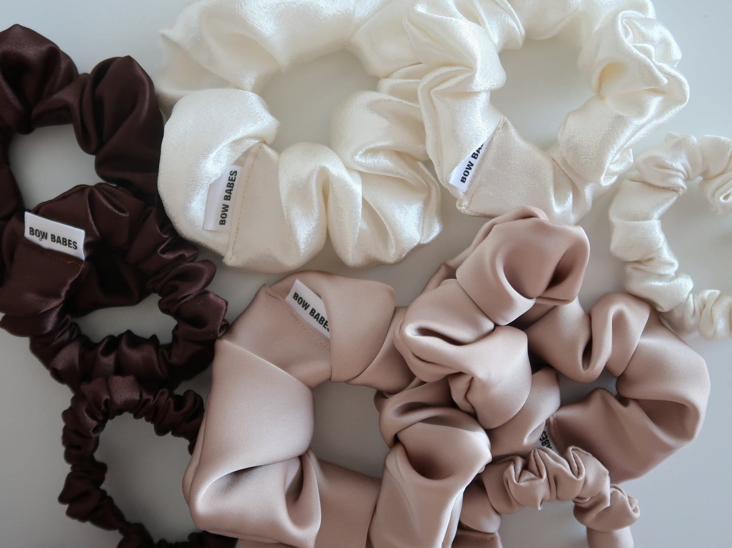 Set of brown, beige, and white scrunchies on a light background