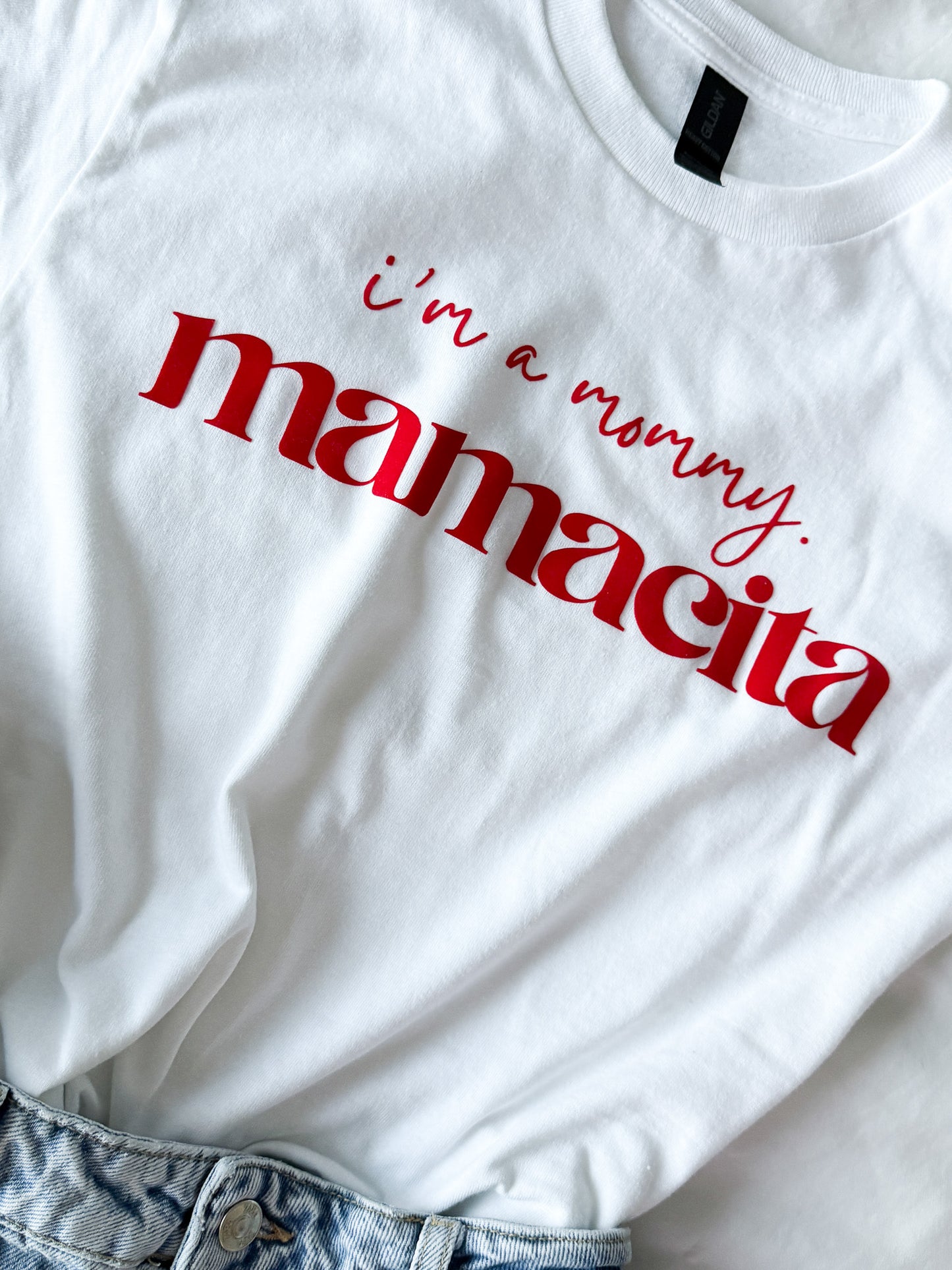 White t-shirt with red text 'i'm a mommy. mamacita' on a white background