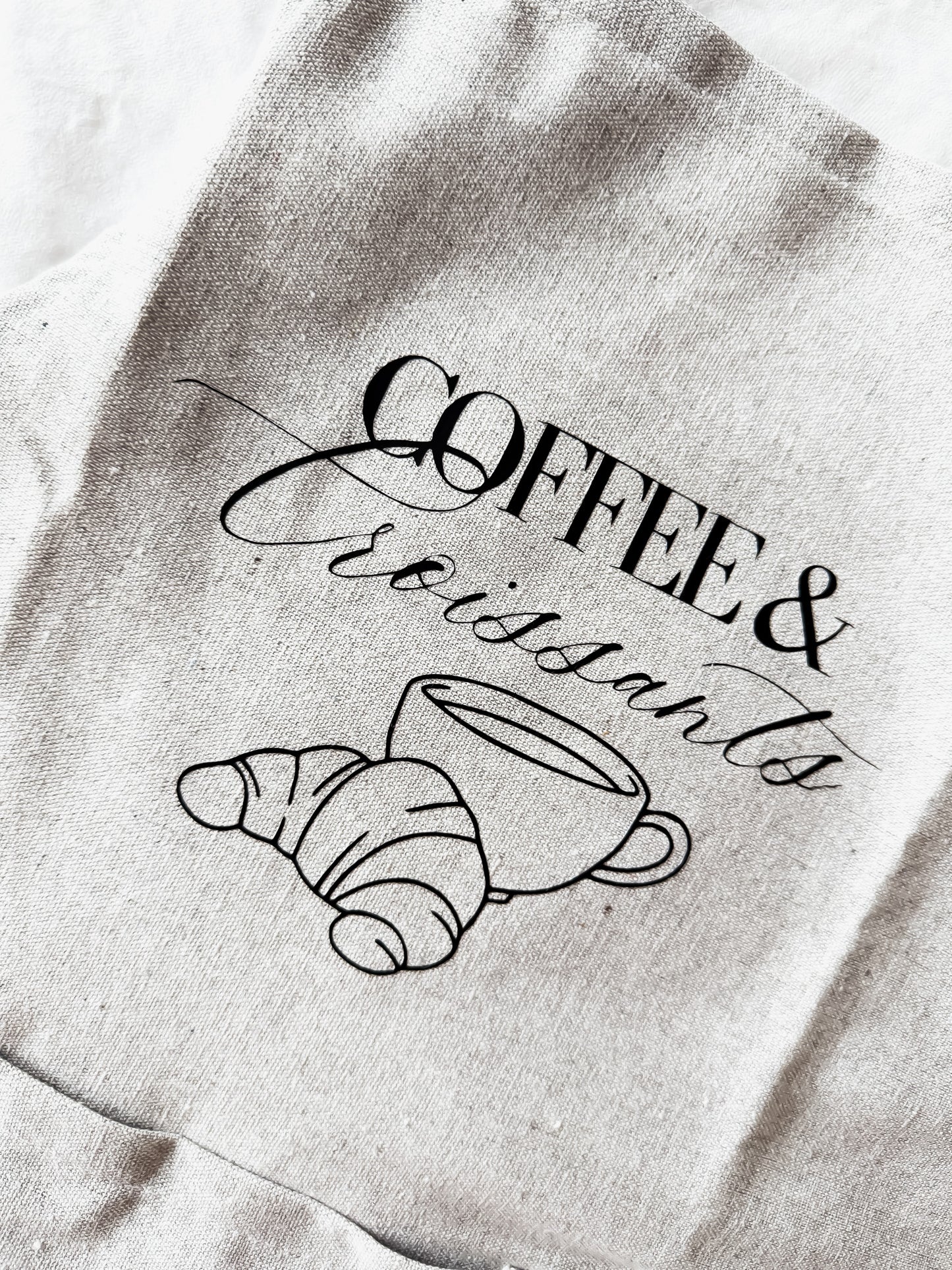 apron with 'Coffee & Croissants' design on a textured background