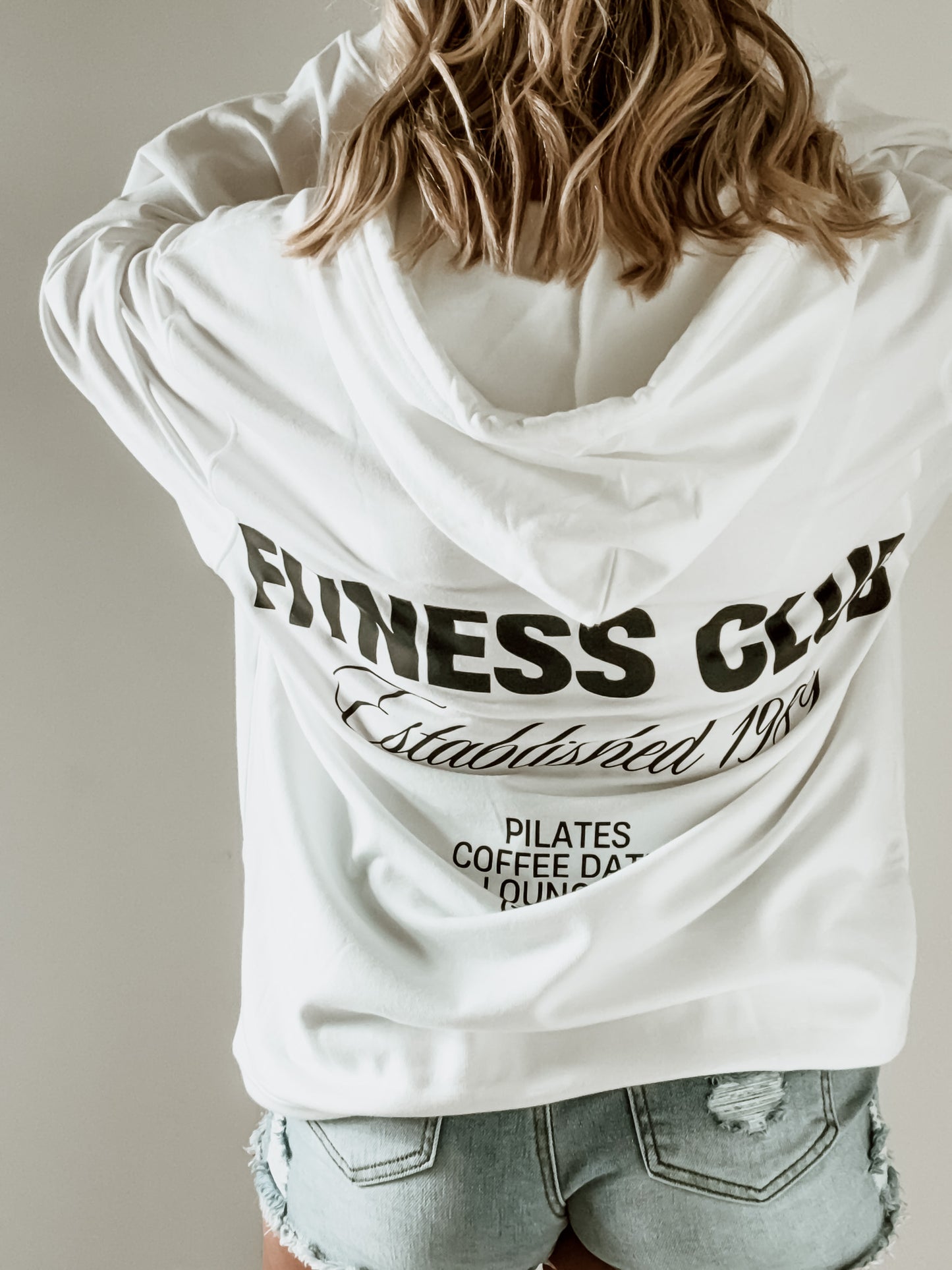 White hoodie with 'Fitness Guy' text on the back, worn by a person.