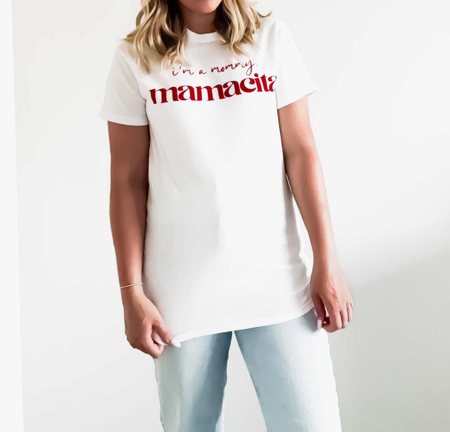 Person wearing a white t-shirt with red text on a plain background