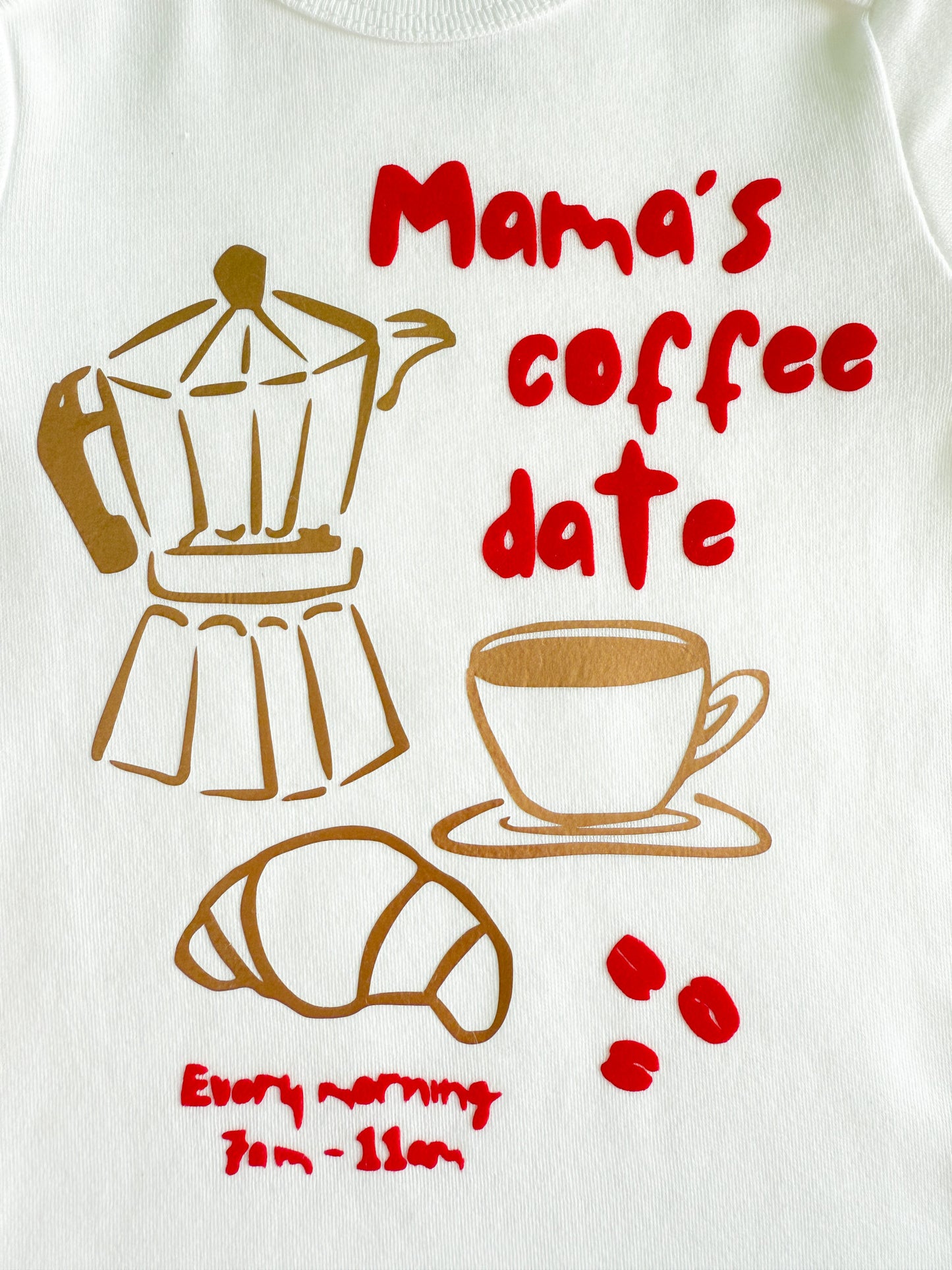 White shirt with coffee-themed design featuring a coffee maker, cup, croissant, and text.
