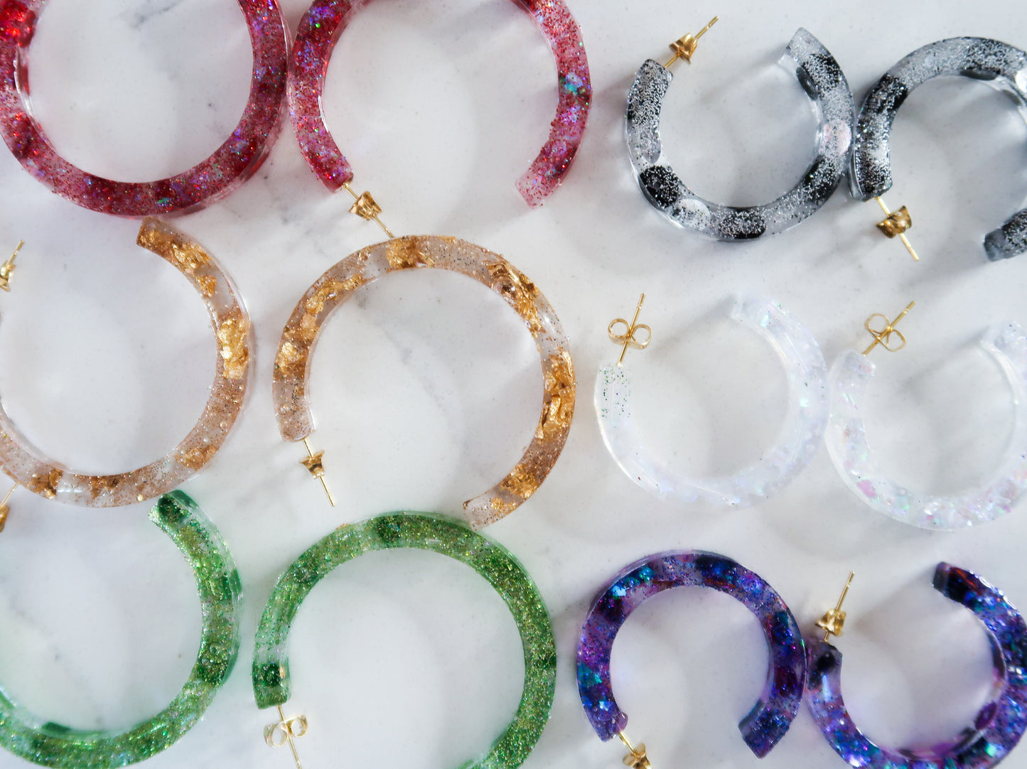 various colored sparkly hoop earrings made of resin