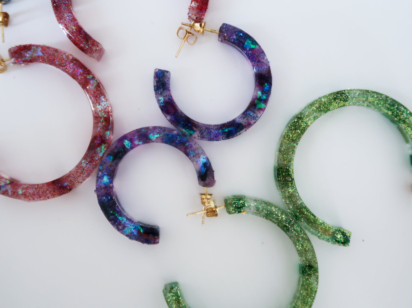 red, purple and green sparkly hoop earrings made of resin