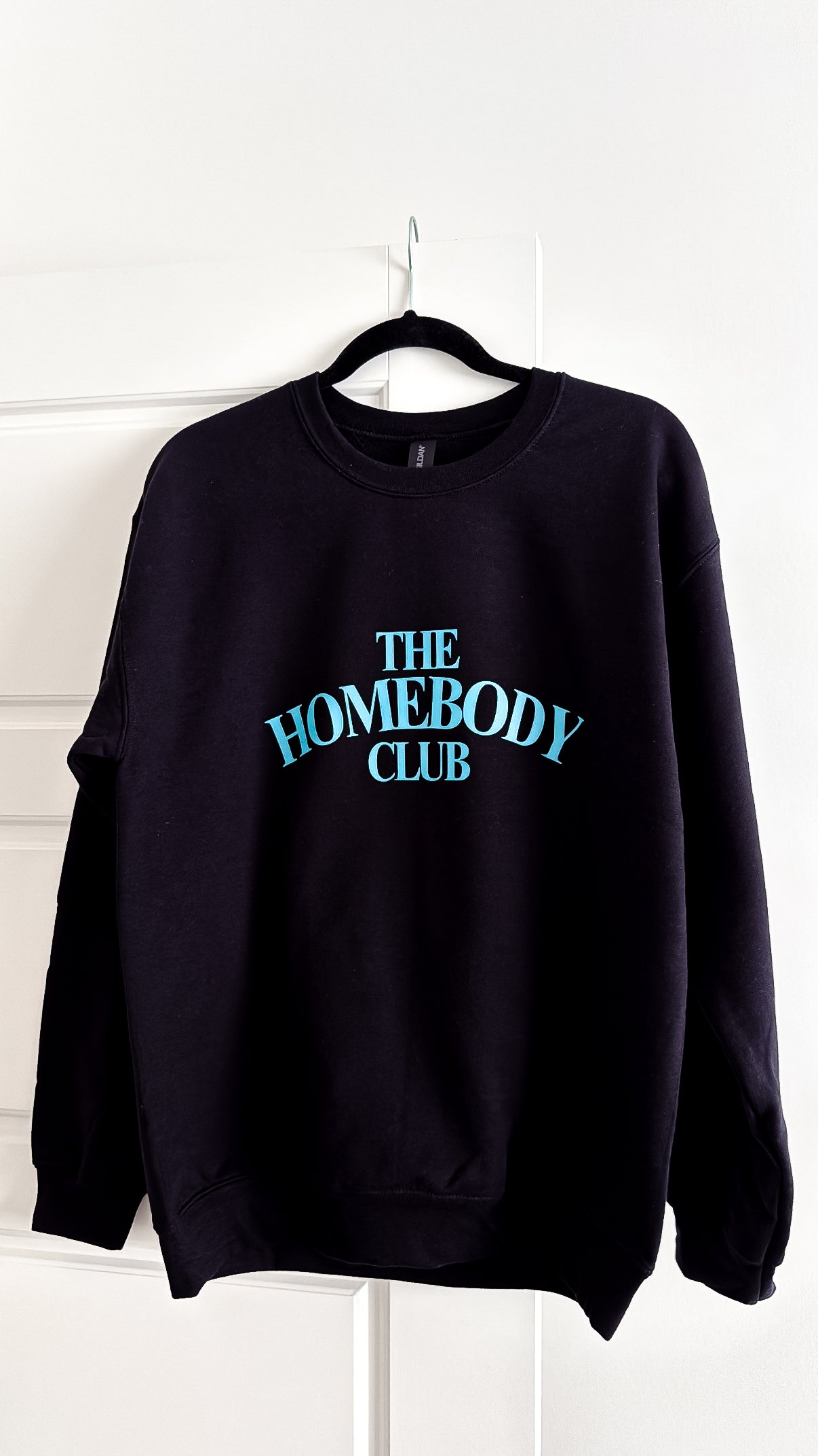 Black sweatshirt with 'The Homebody Club' text on a white background