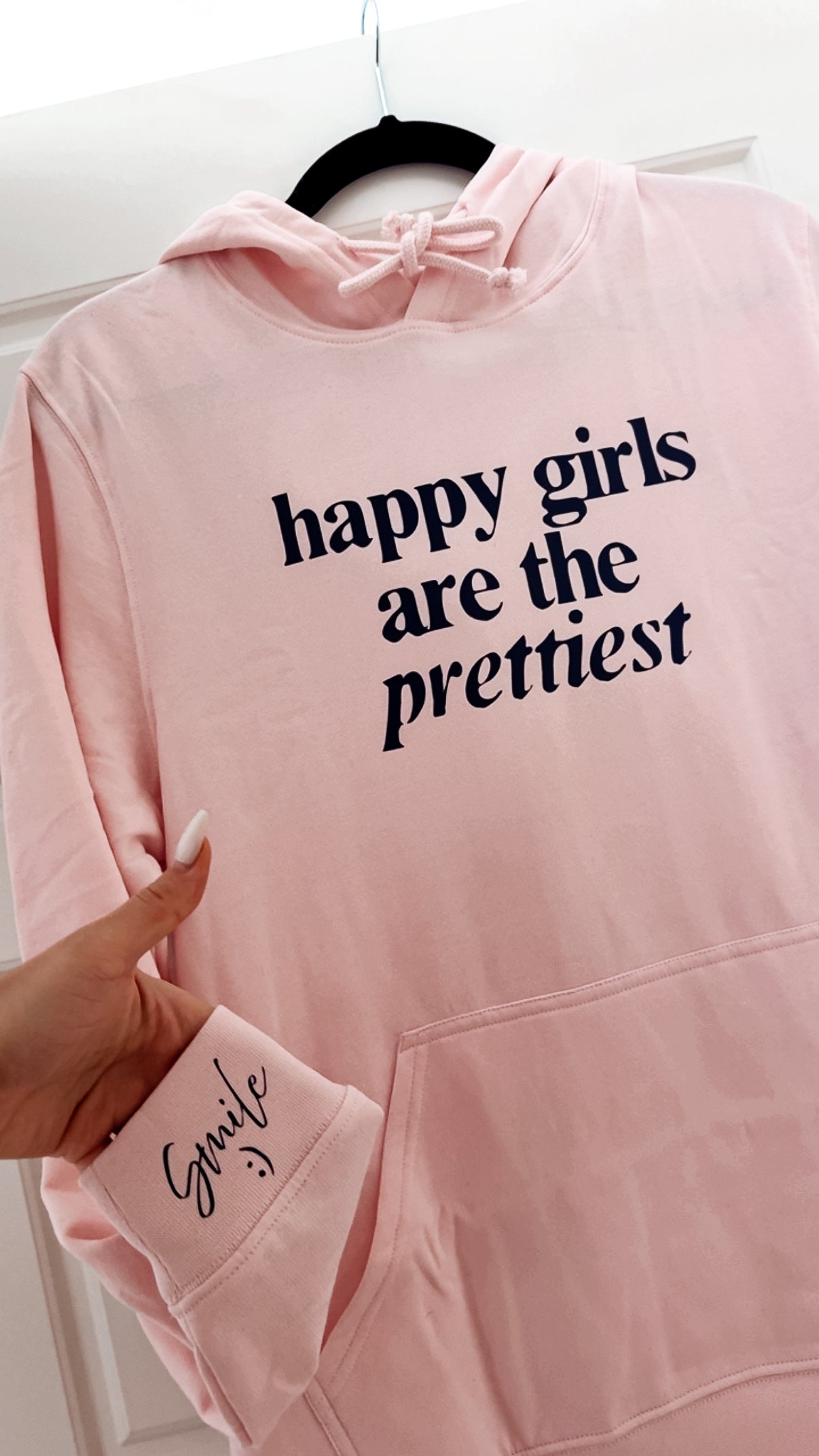 Pink hoodie with 'happy girls are the prettiest' text on a white background