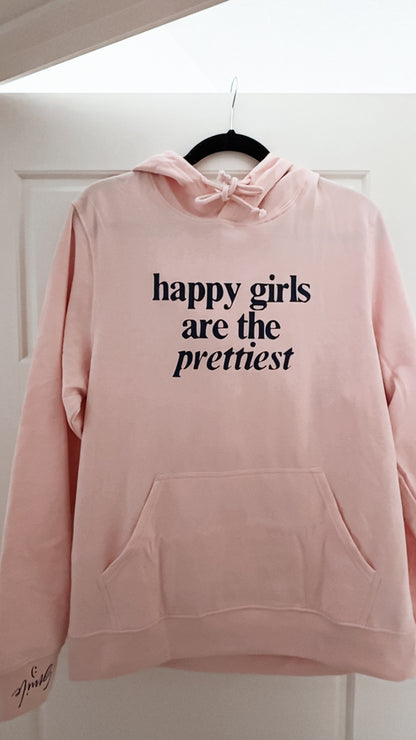 Pink hoodie with 'happy girls are the prettiest' text on a white background