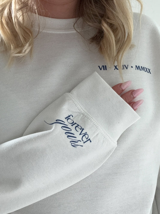 White sweatshirt with 'forever yours' embroidery on a blurred background