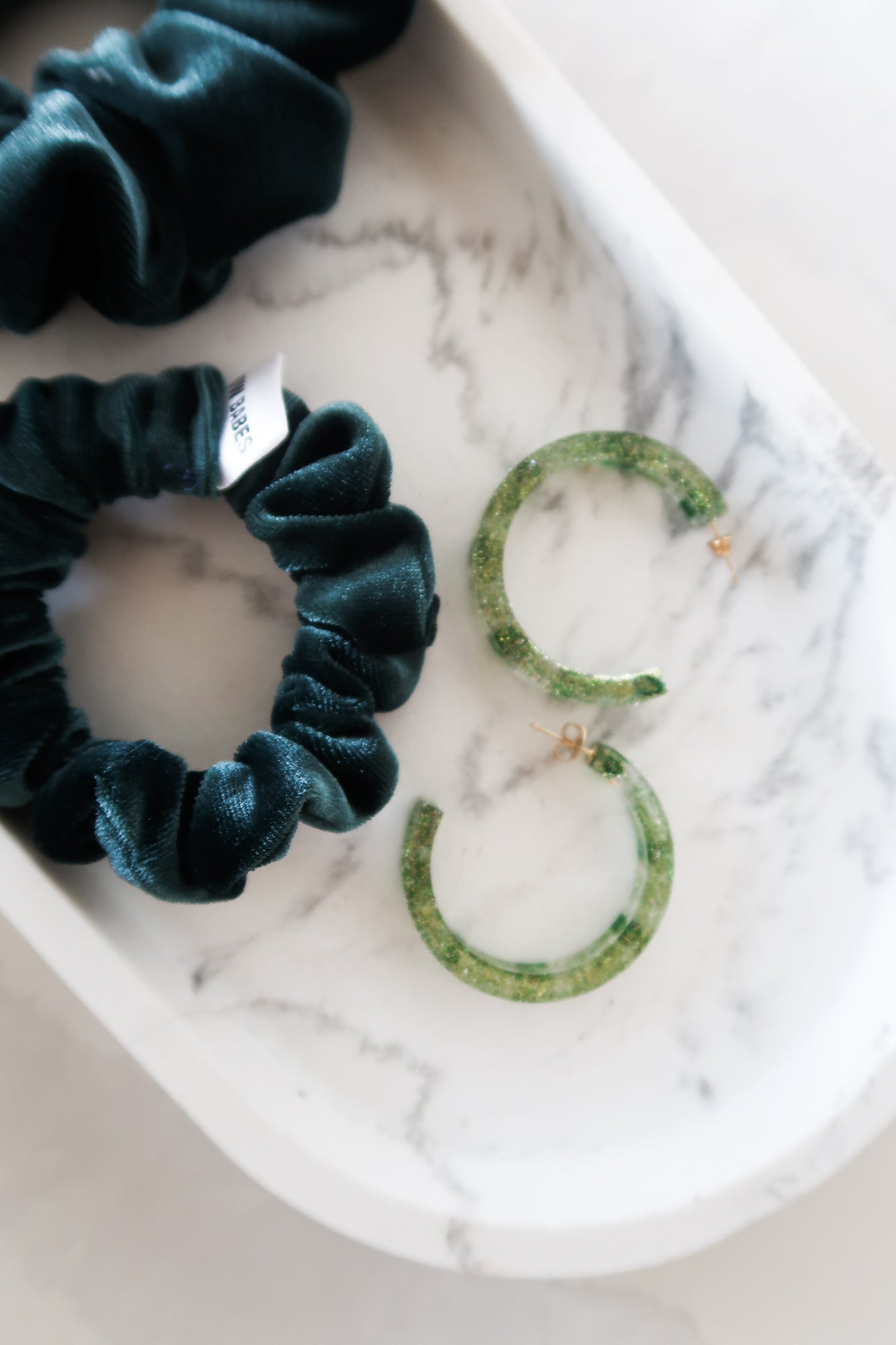 Handmade green sparkly resin earrings paired with velvet scrunchies