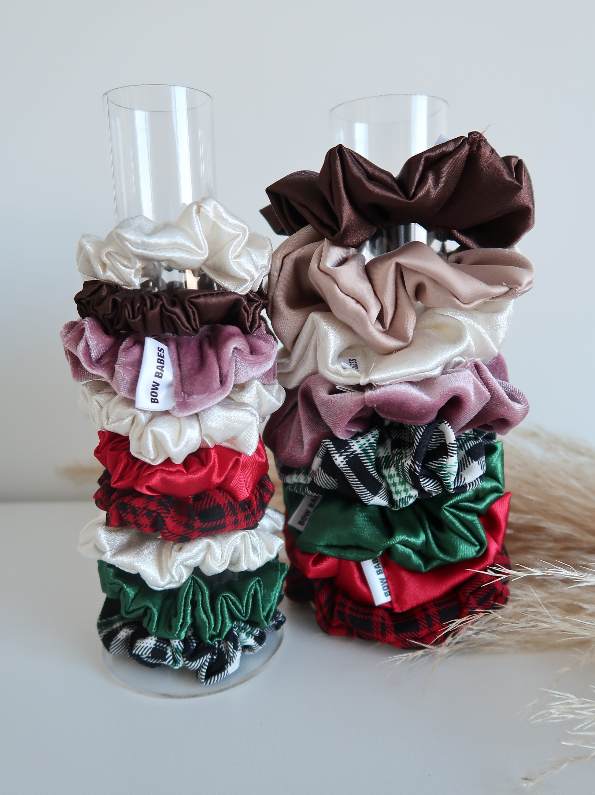 Stack of colorful scrunchies on a clear stand against a white background
