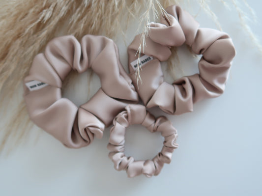 Three pink scrunchies on a light background