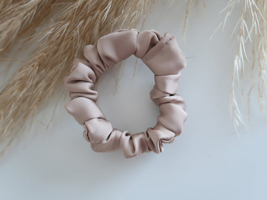 Pink scrunchie on a light background with dried grasses