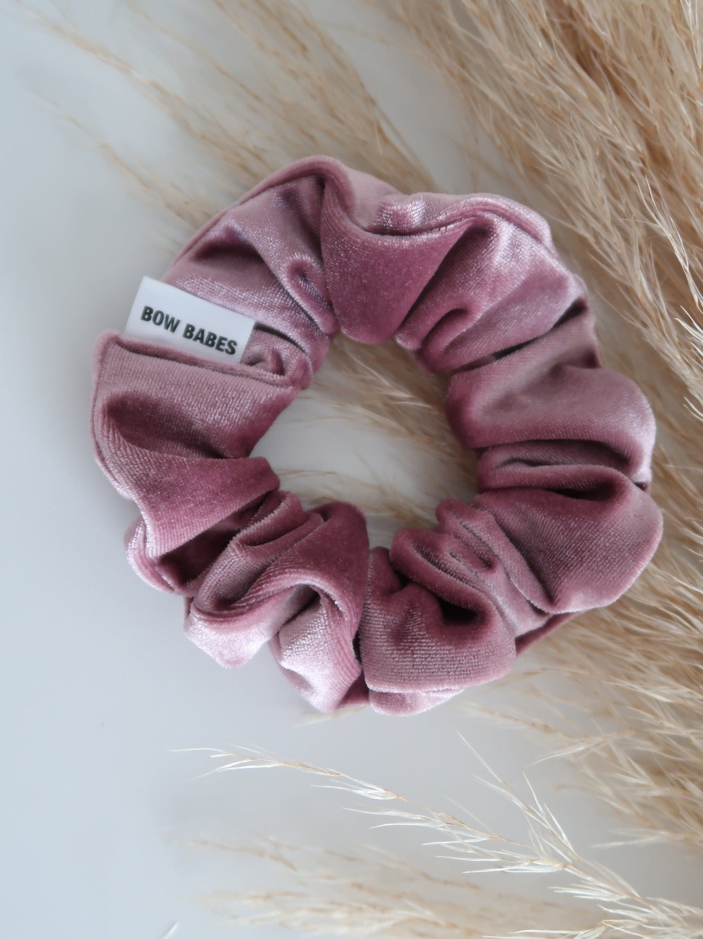 Pink scrunchie with a label on a light background