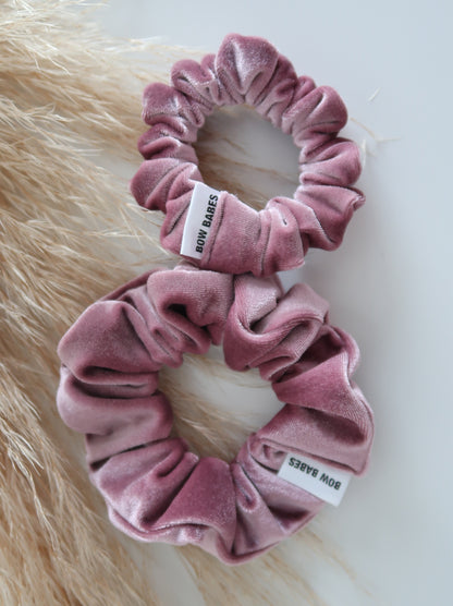 Two pink velvet scrunchies with 'Bow Babes' label on a light background