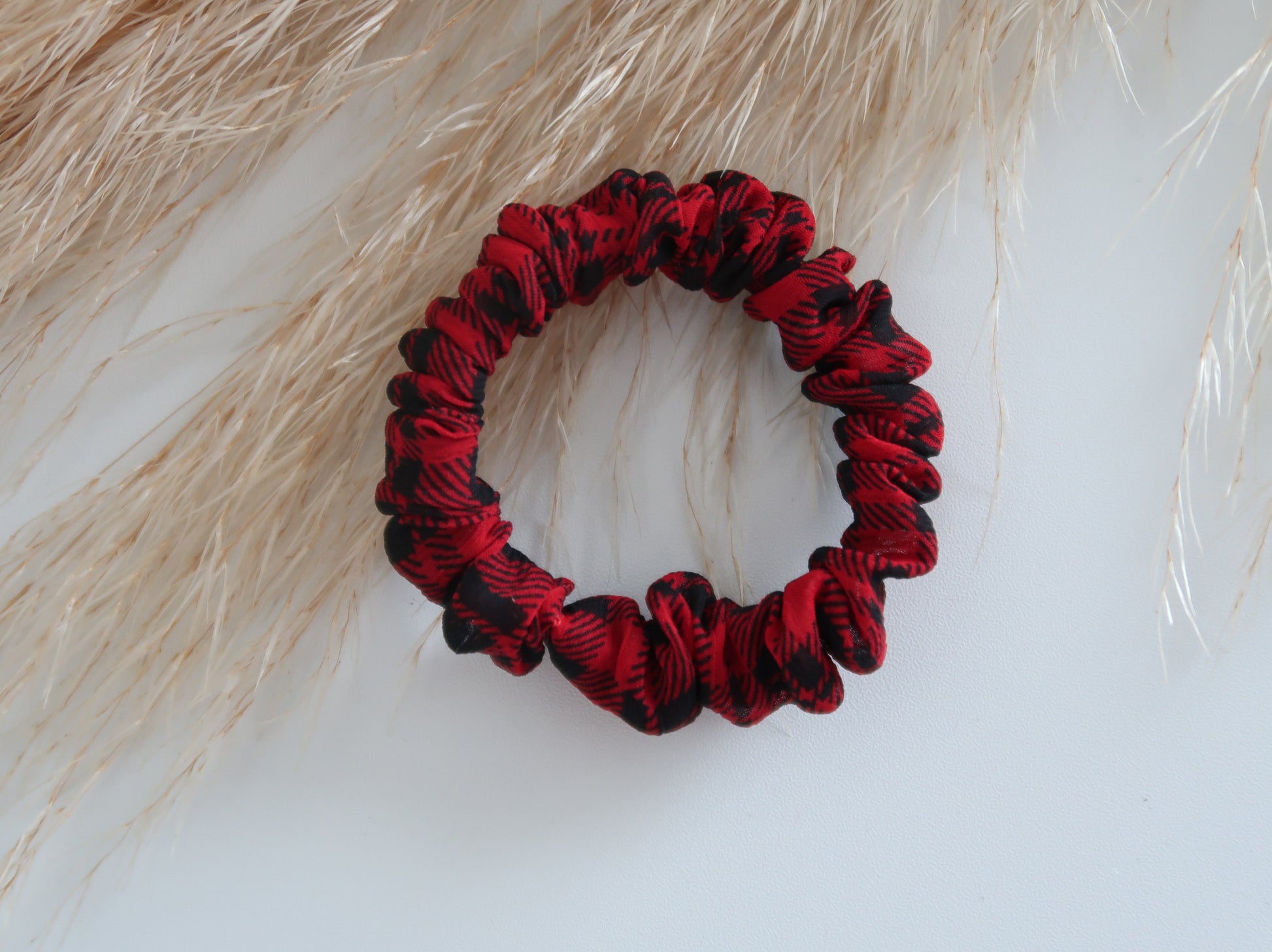 Red and black scrunchie on a textured white surface