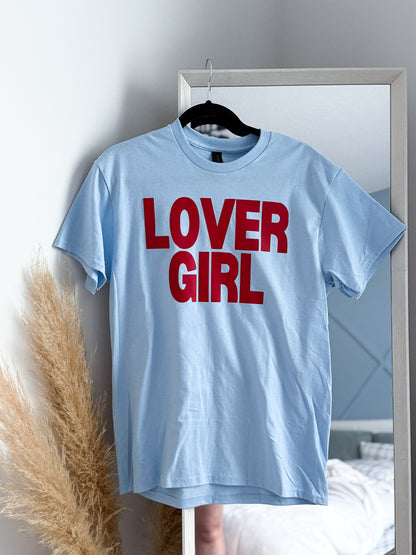 Light blue t-shirt with 'LOVER GIRL' text in red on a hanger.