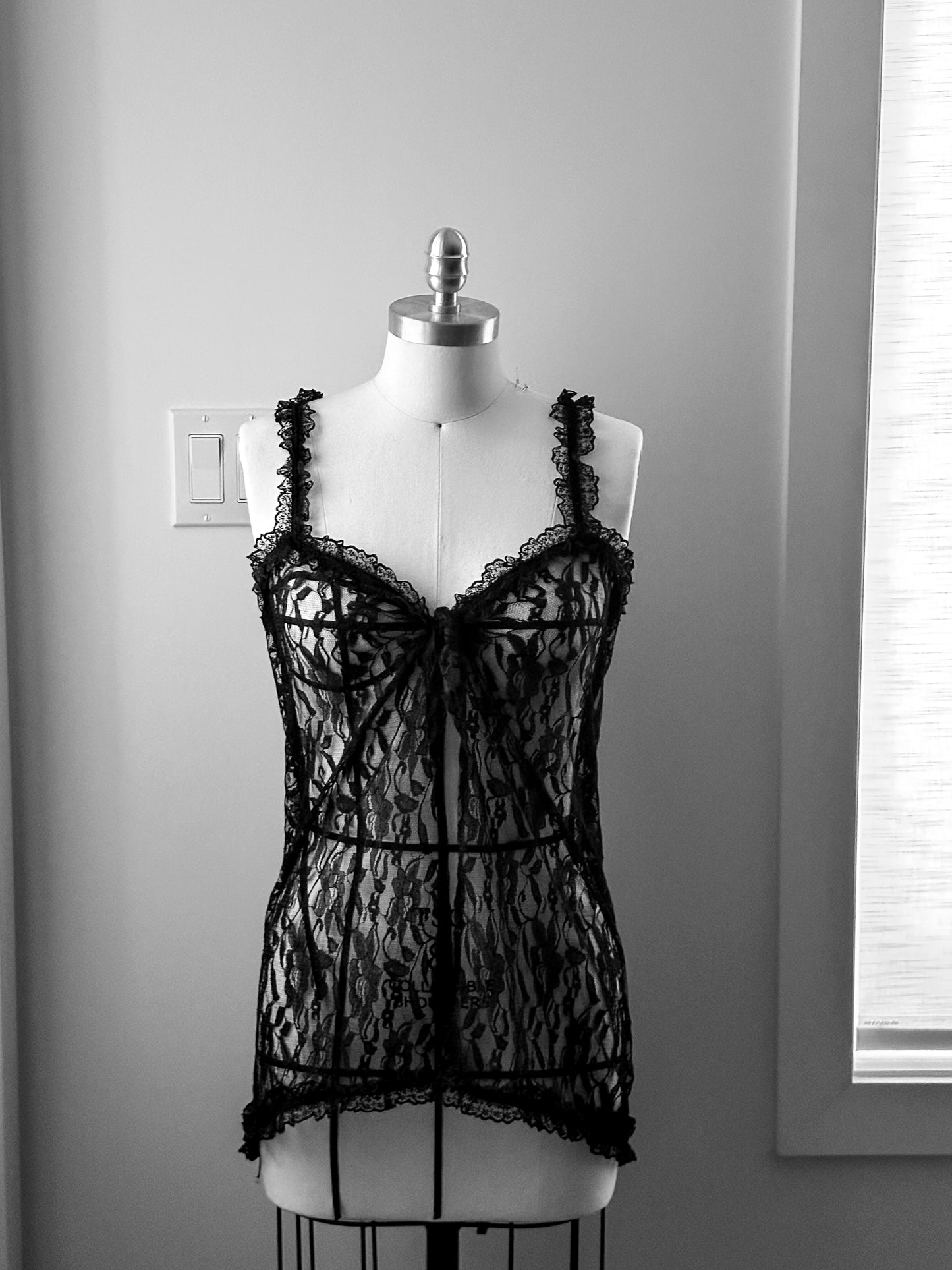Black lace lingerie on a mannequin against a neutral background