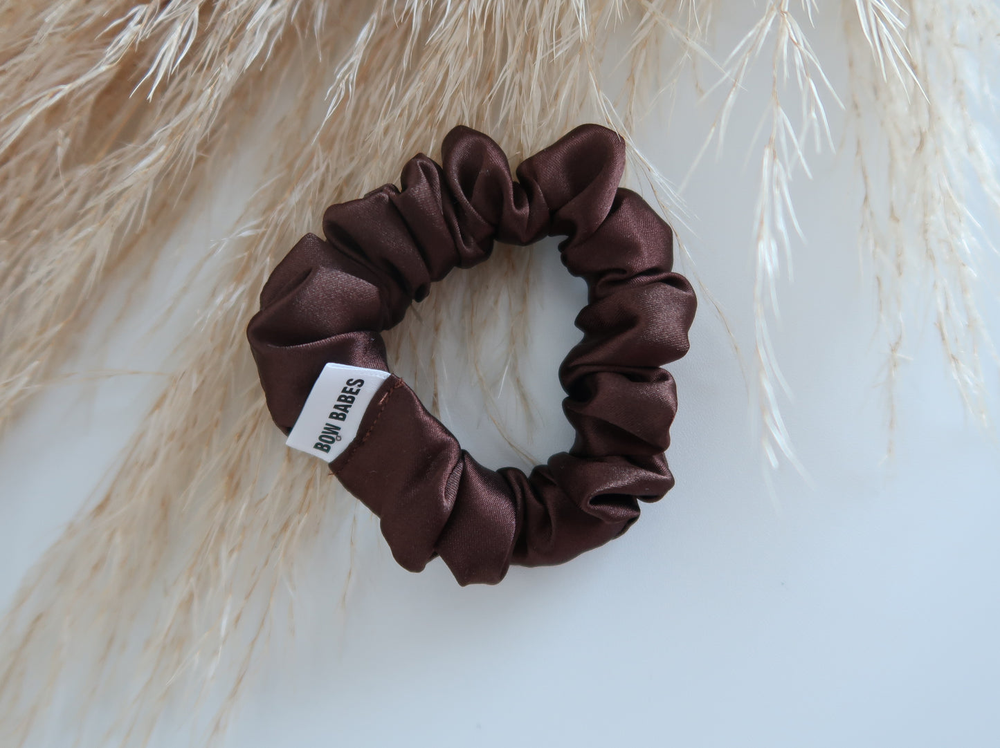 Brown scrunchie with a label on a light background
