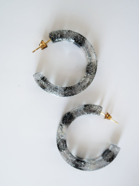 small silver & black sparkly hoop earrings made of resin