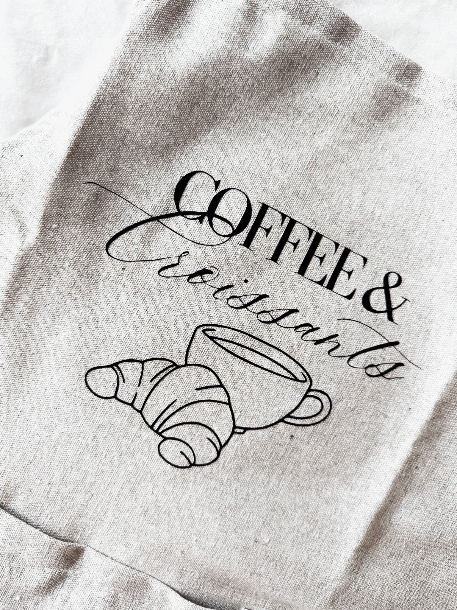 apron with 'Coffee & Croissants' design on a textured background