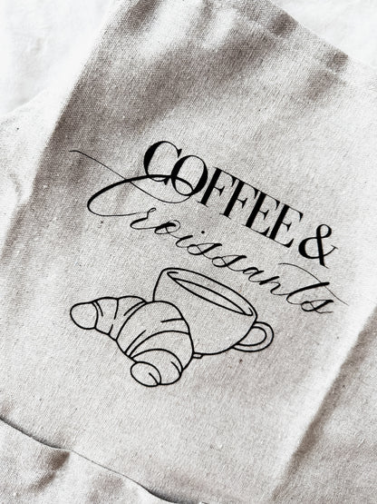 apron with 'Coffee & Croissants' design on a textured background