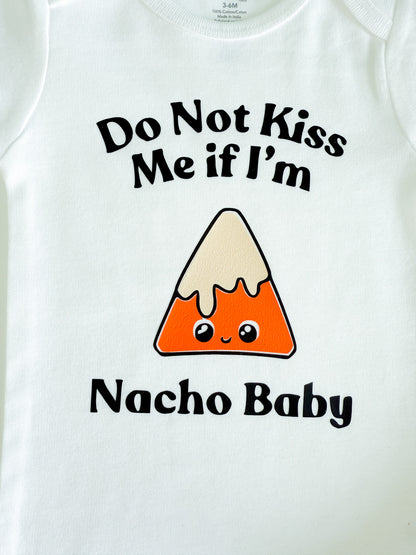 White baby onesie with nacho graphic and text 'Do Not Kiss Me if I'm Nacho Baby' on a white background