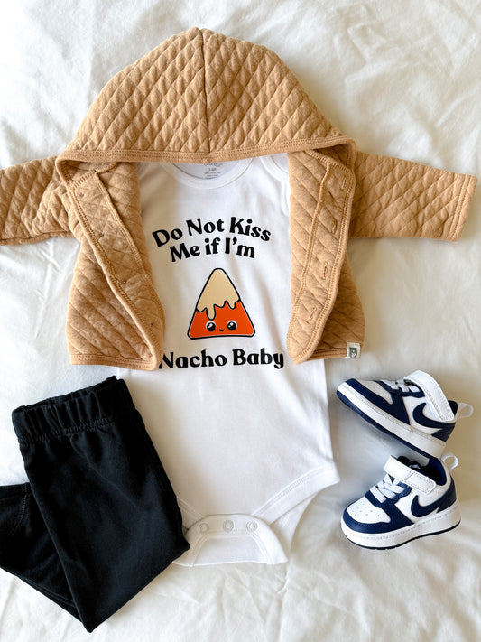 Baby outfit with white shirt, beige jacket, black pants, and blue sneakers on a white background