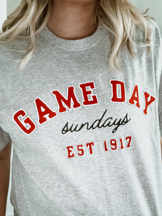 Gray t-shirt with 'GAME DAY Sundays EST 1917' text in red and black.