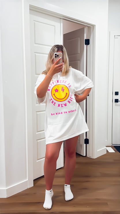 Person wearing a white oversized t-shirt with a graphic design in a room.