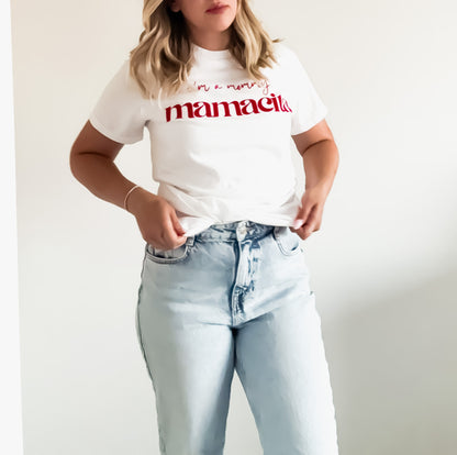 Person wearing a white t-shirt with red text and light blue jeans on a plain background