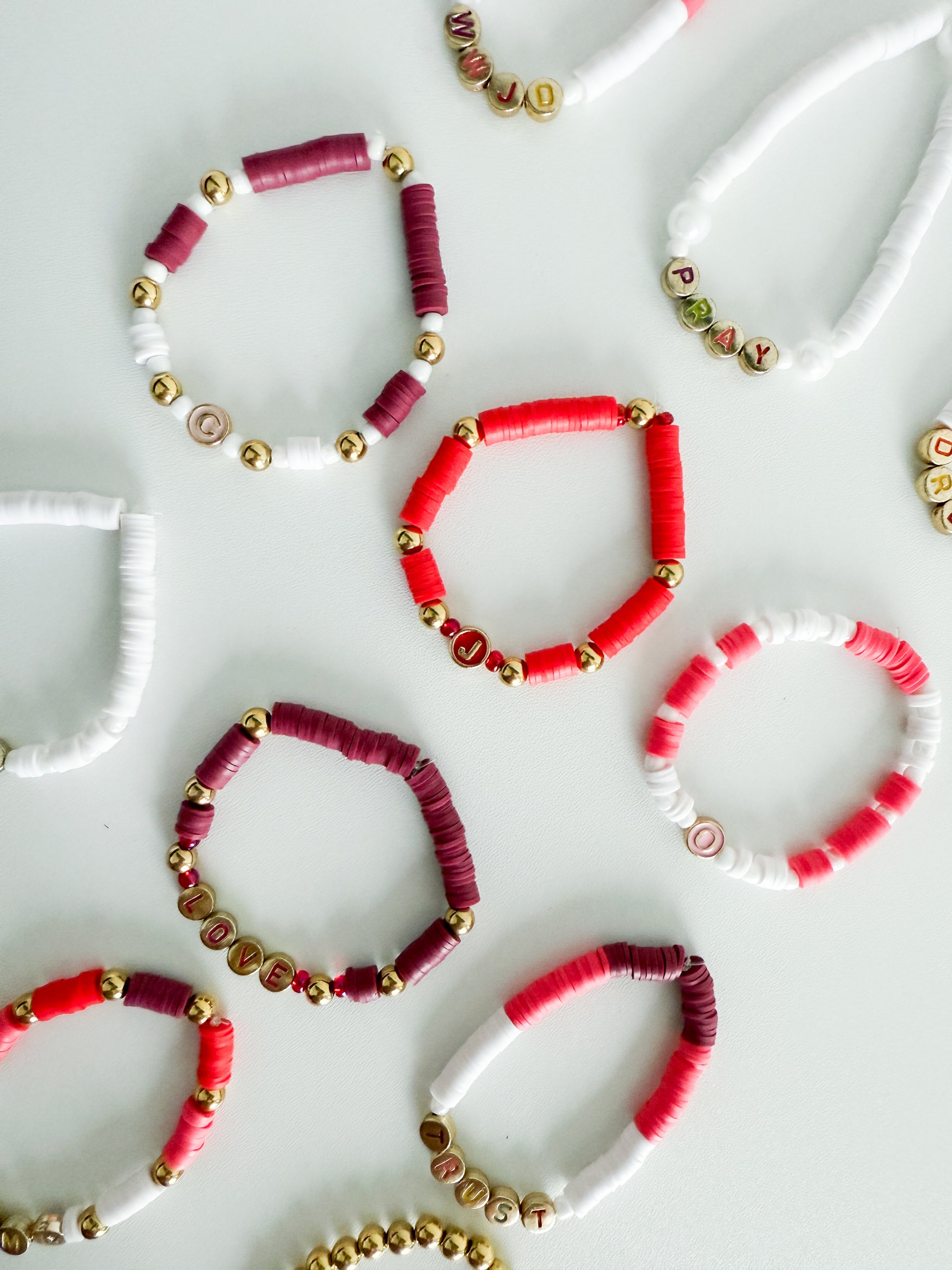 Colorful beaded bracelets on a white textured surface