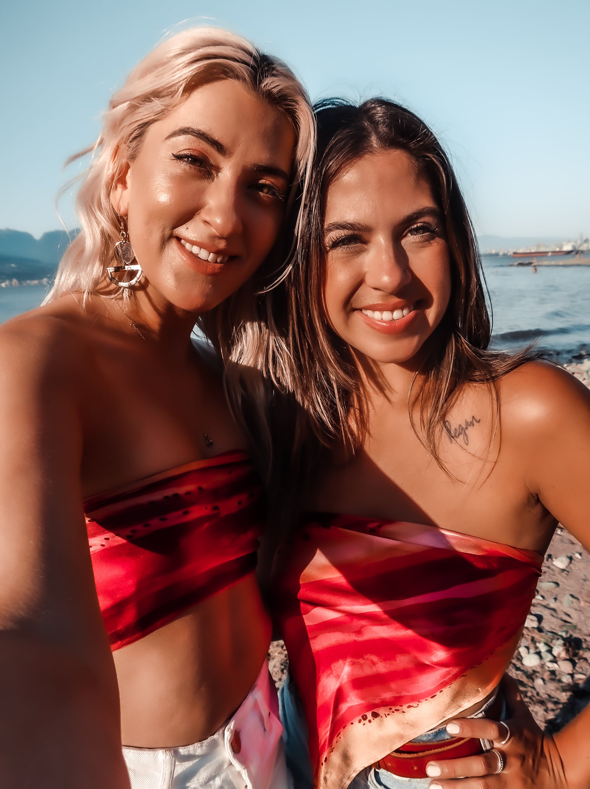 two women wearing silk summer tops on the beach