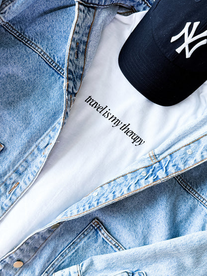 Denim jacket with 'reading is my therapy' tattoo and New York Yankees cap.