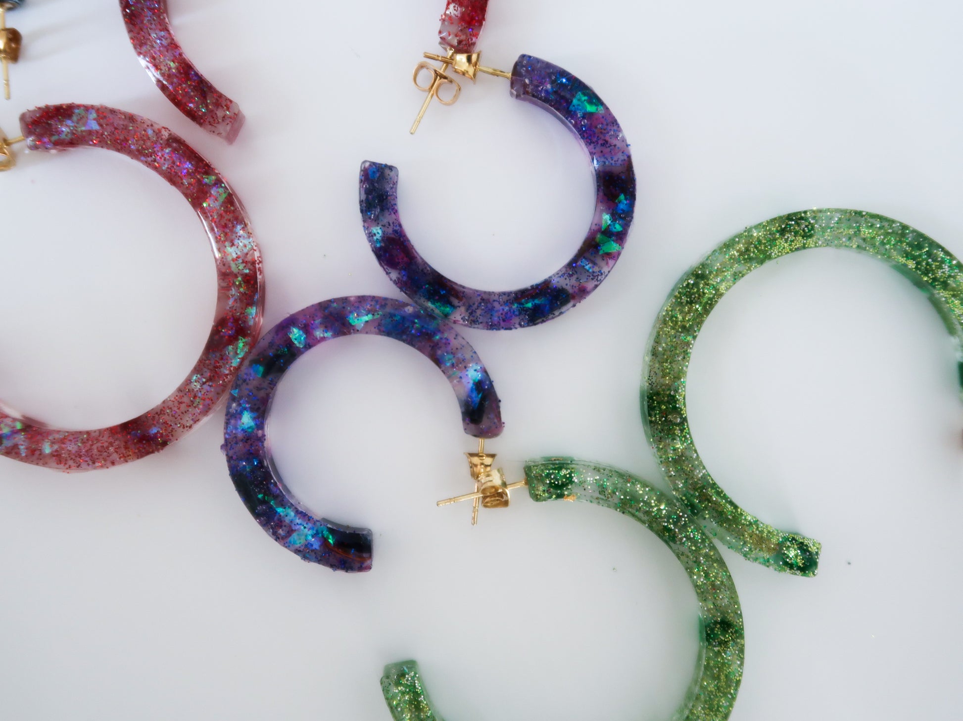 red, purple and green sparkly hoop earrings made of resin