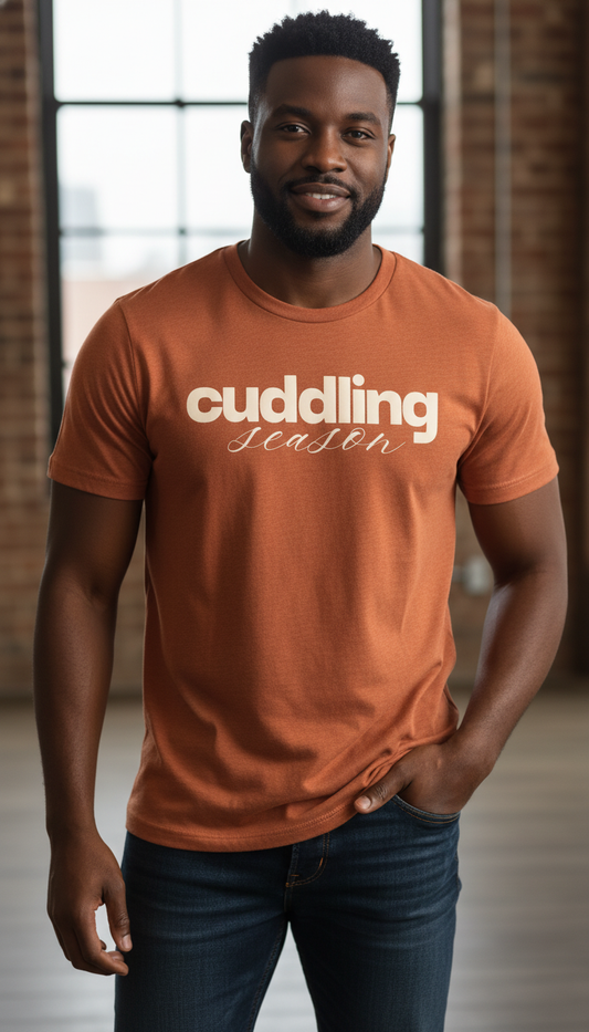 Man wearing an orange t-shirt with 'cuddling season' text in a casual setting