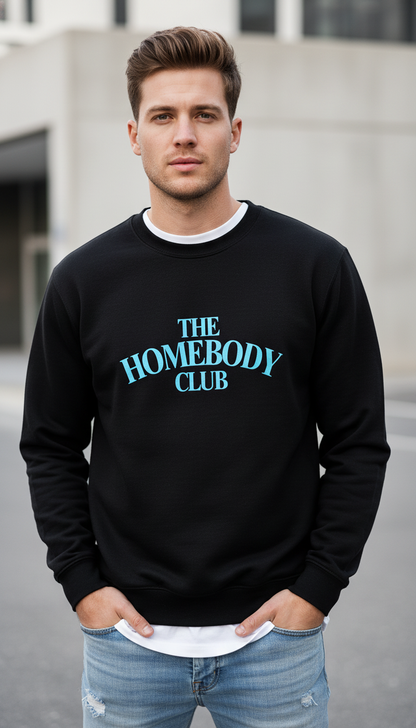 Man wearing a black sweatshirt with 'The Homebody Club' text outdoors.